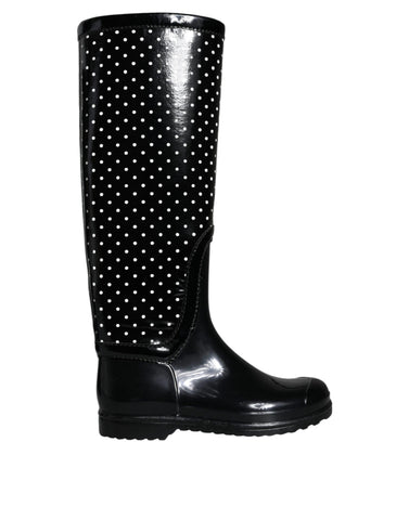 Black polka dot rubber knee-high boots by Dolce & Gabbana with a glossy finish and rounded toe, stylish and waterproof footwear.