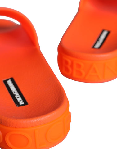 Orange rubber slides sandals by Dolce & Gabbana with open toe design and casual beachwear style.