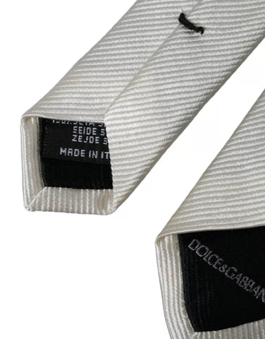 White solid 100% silk adjustable tie by Dolce & Gabbana, displayed flat with detailed fabric texture and classic design.