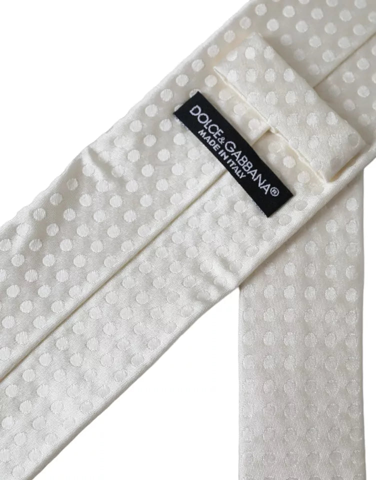 White dotted silk men's tie by Dolce & Gabbana with adjustable length and classic style, shown laid flat.
