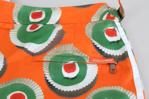 Orange cupcake print beachwear shorts by Dolce & Gabbana, featuring a playful swimwear design with a bright, vibrant pattern.