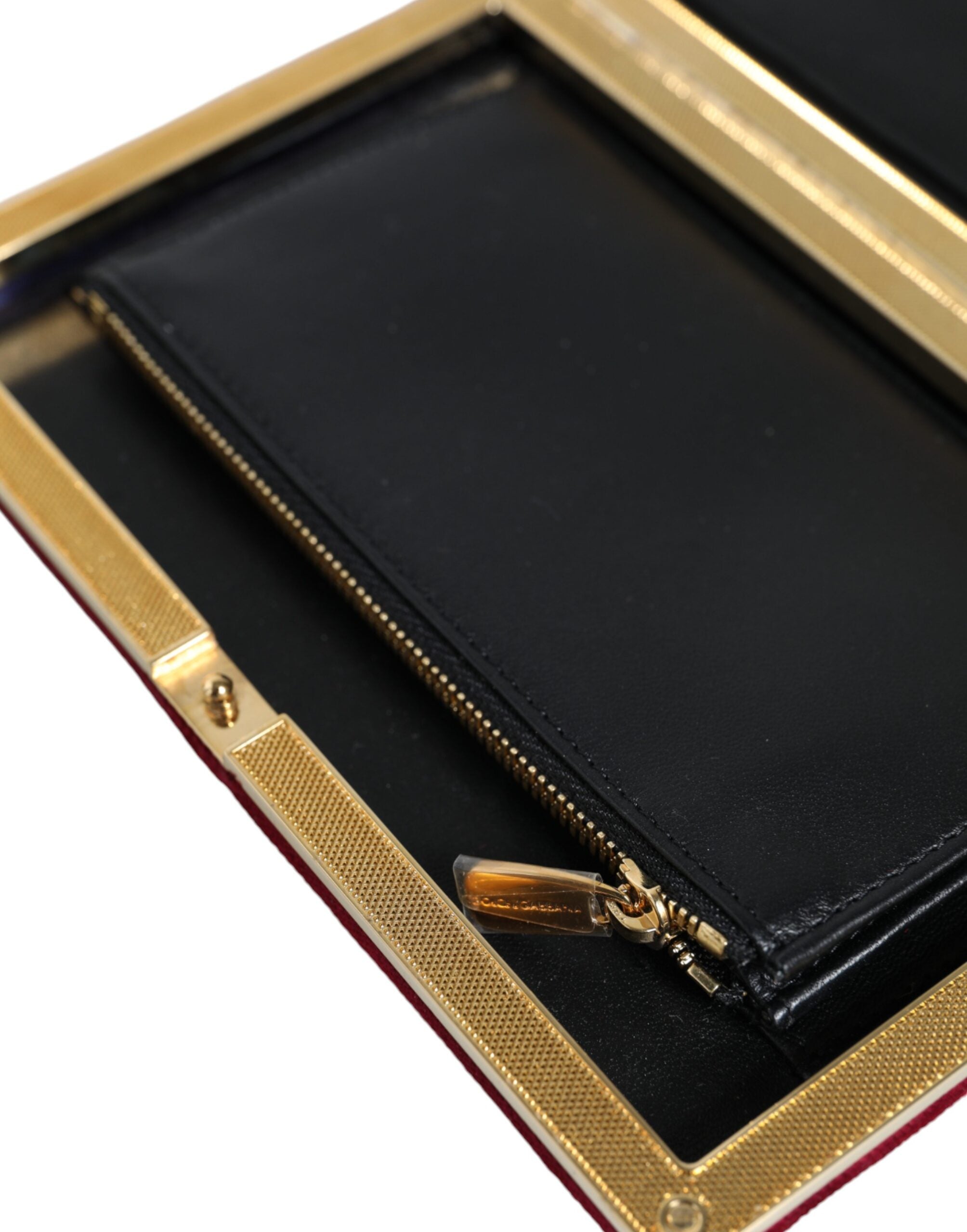 Red velvet clutch purse with gold frame and clasp, elegant evening party bag by Dolce & Gabbana, featuring a sleek design.