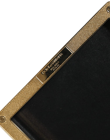 Black leather clutch purse with gold frame and stud details, designed by Dolce & Gabbana for evening events.