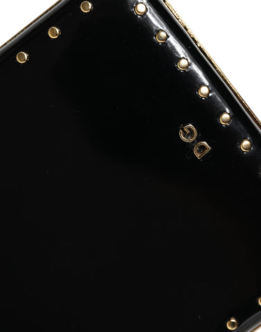 Black leather clutch purse with gold frame and stud accents, designed by Dolce & Gabbana, ideal for evening events.