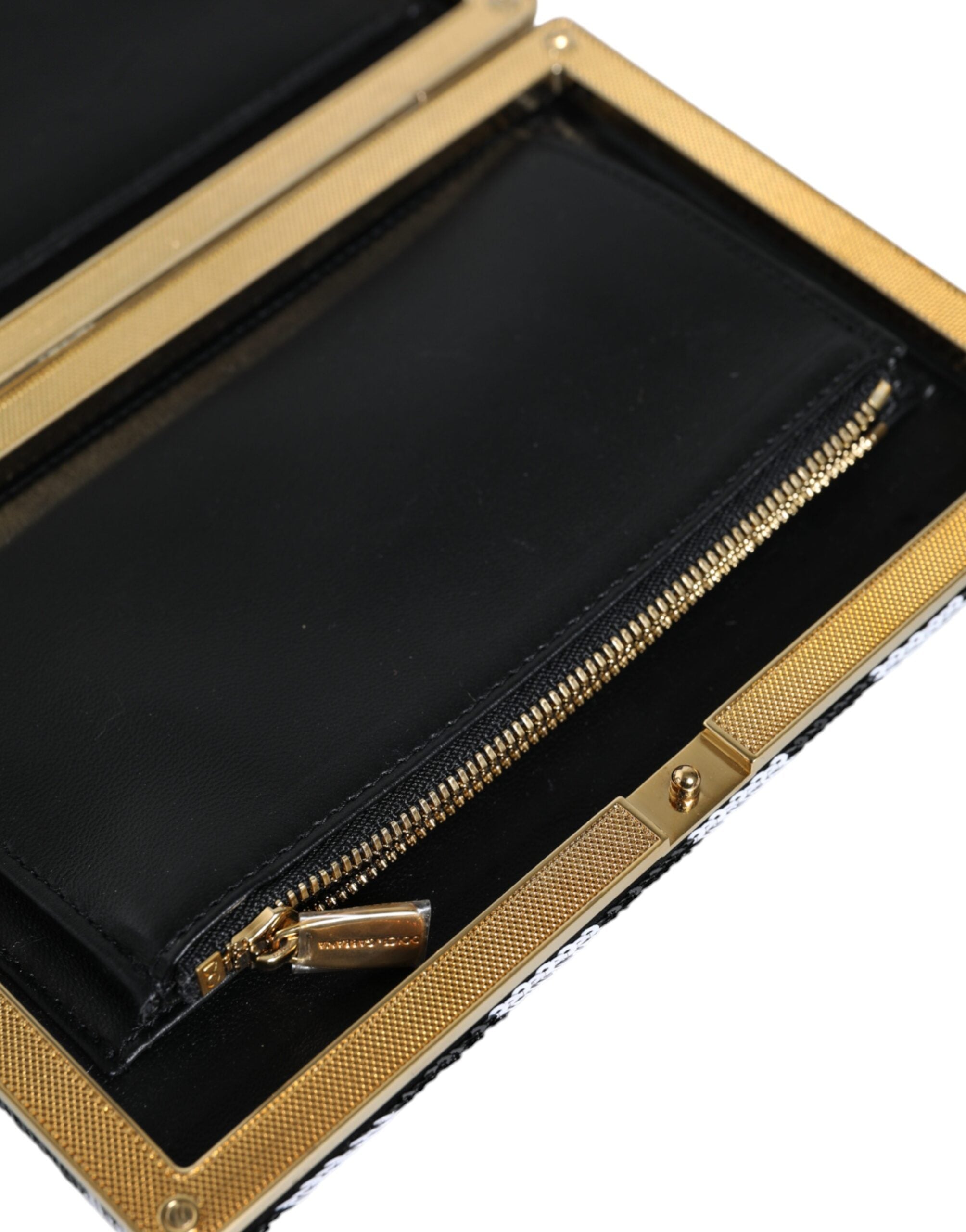 Black and white Dolce & Gabbana clutch purse with gold frame, evening party bag with elegant design and sleek finish.