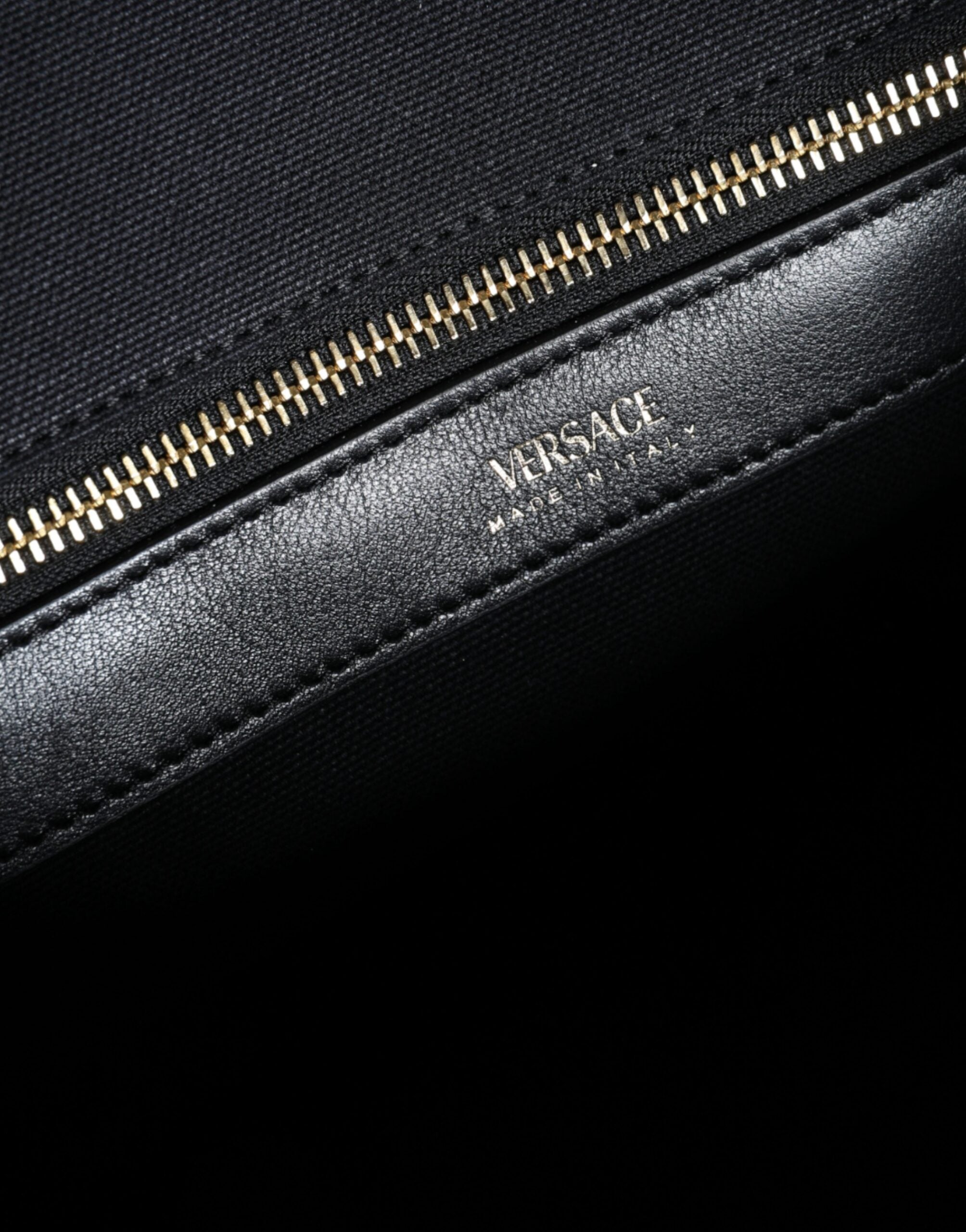 Versace black top handle canvas and leather logo crossbody tote bag with spacious interior and sturdy straps.