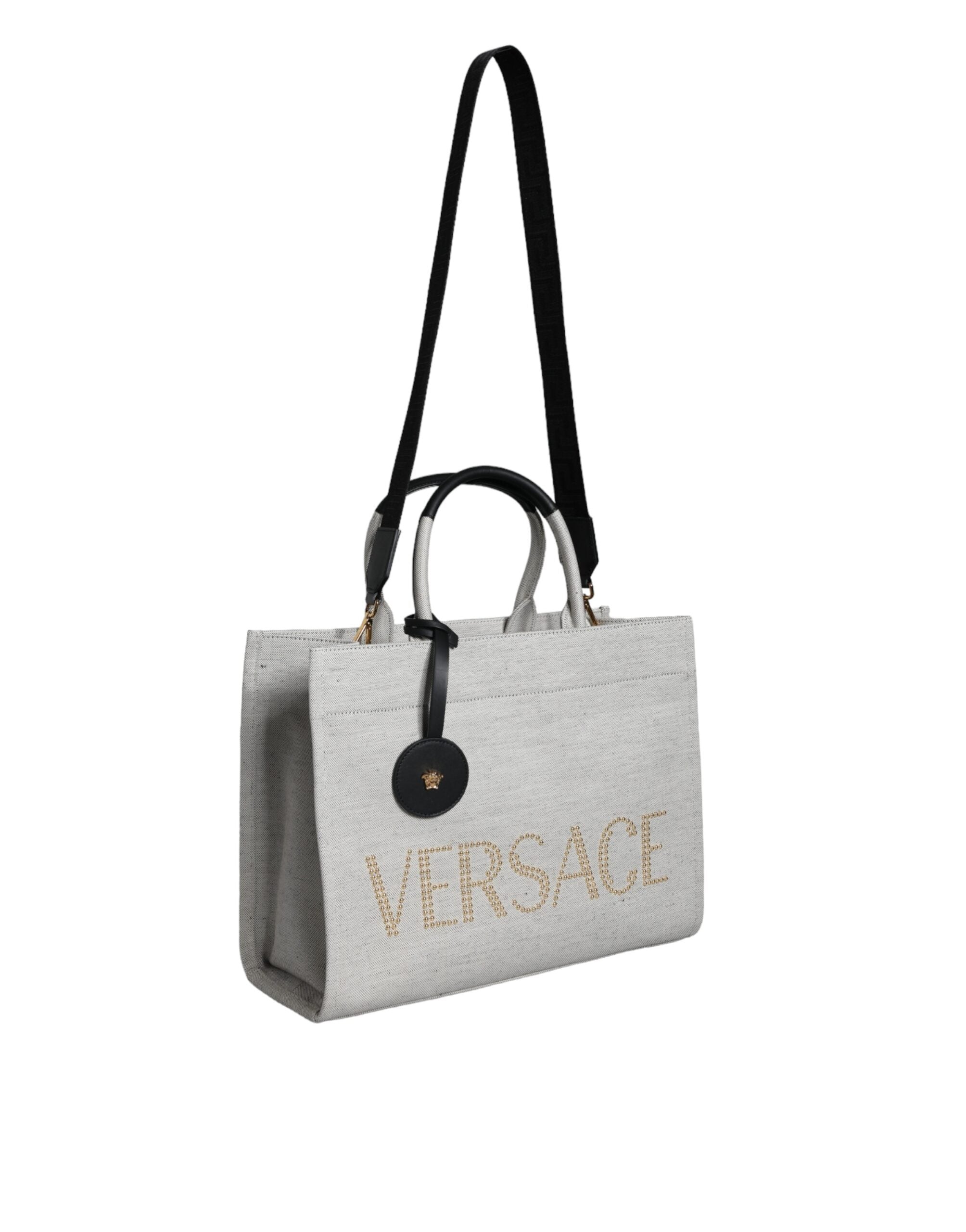 Versace white top handle canvas leather logo crossbody tote bag with structured design and adjustable strap.