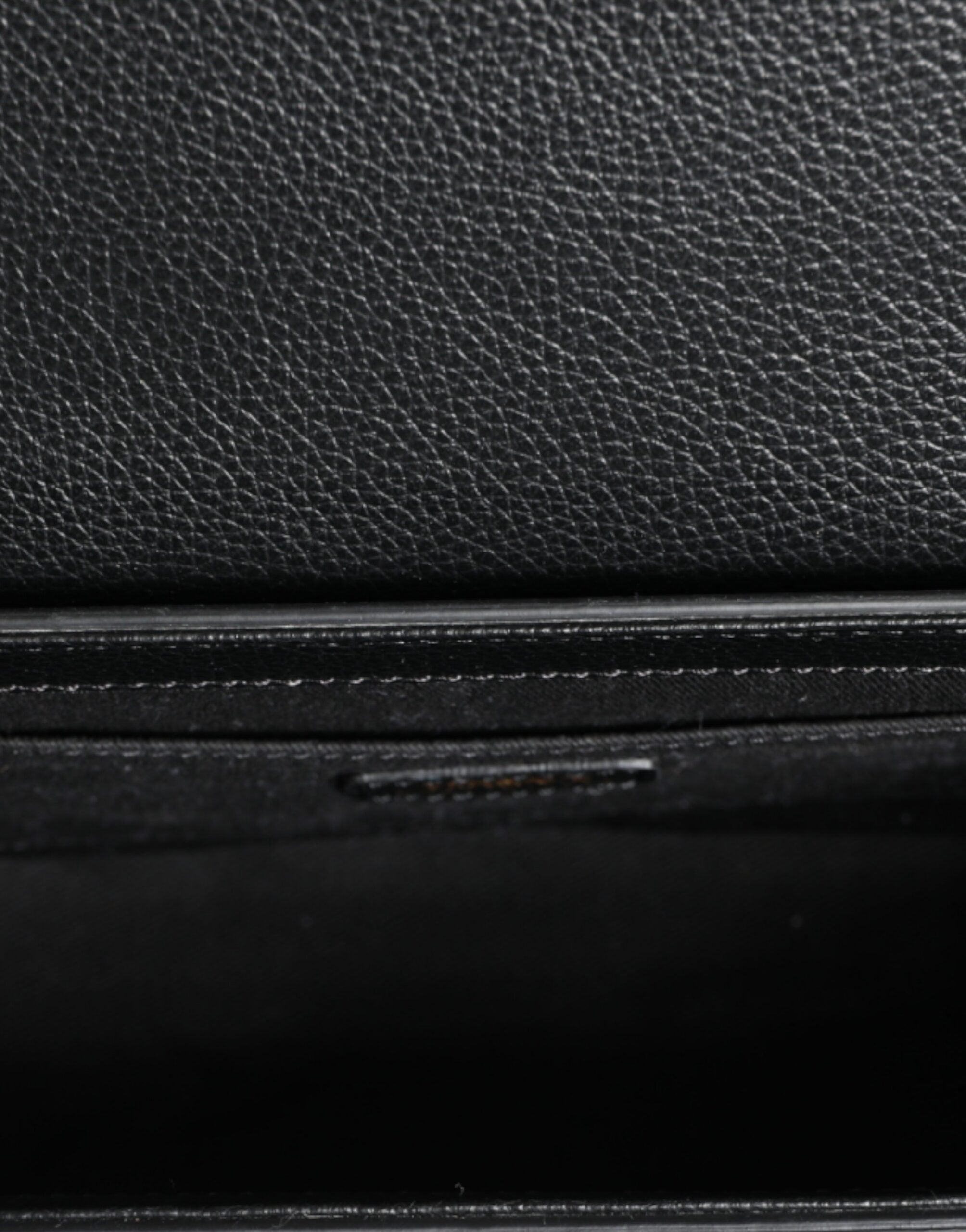 Black grainy calf leather Versace crossbody shoulder bag with logo detail and adjustable strap.