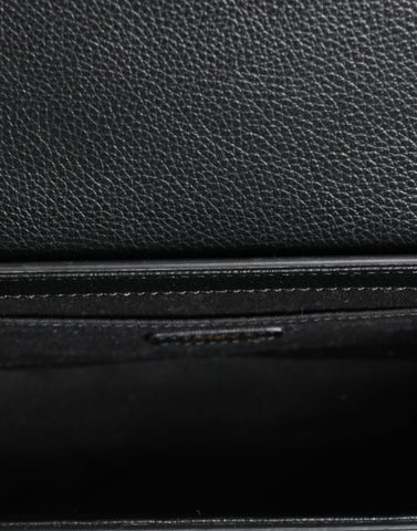 Black grainy calf leather Versace crossbody shoulder bag with logo detail and adjustable strap.