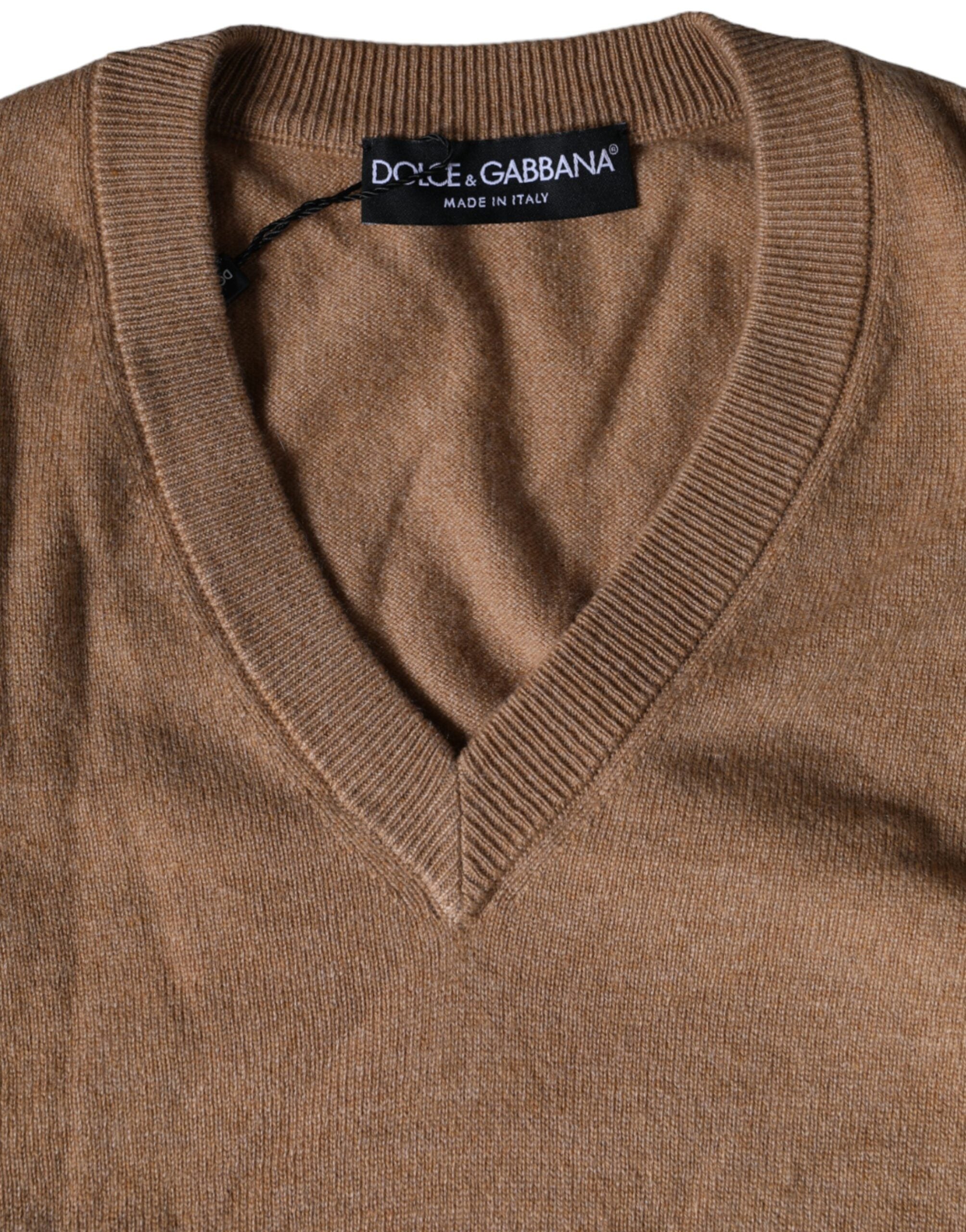 Brown cashmere knit V-neck pullover sweater by Dolce & Gabbana, shown on a hanger with a textured background.