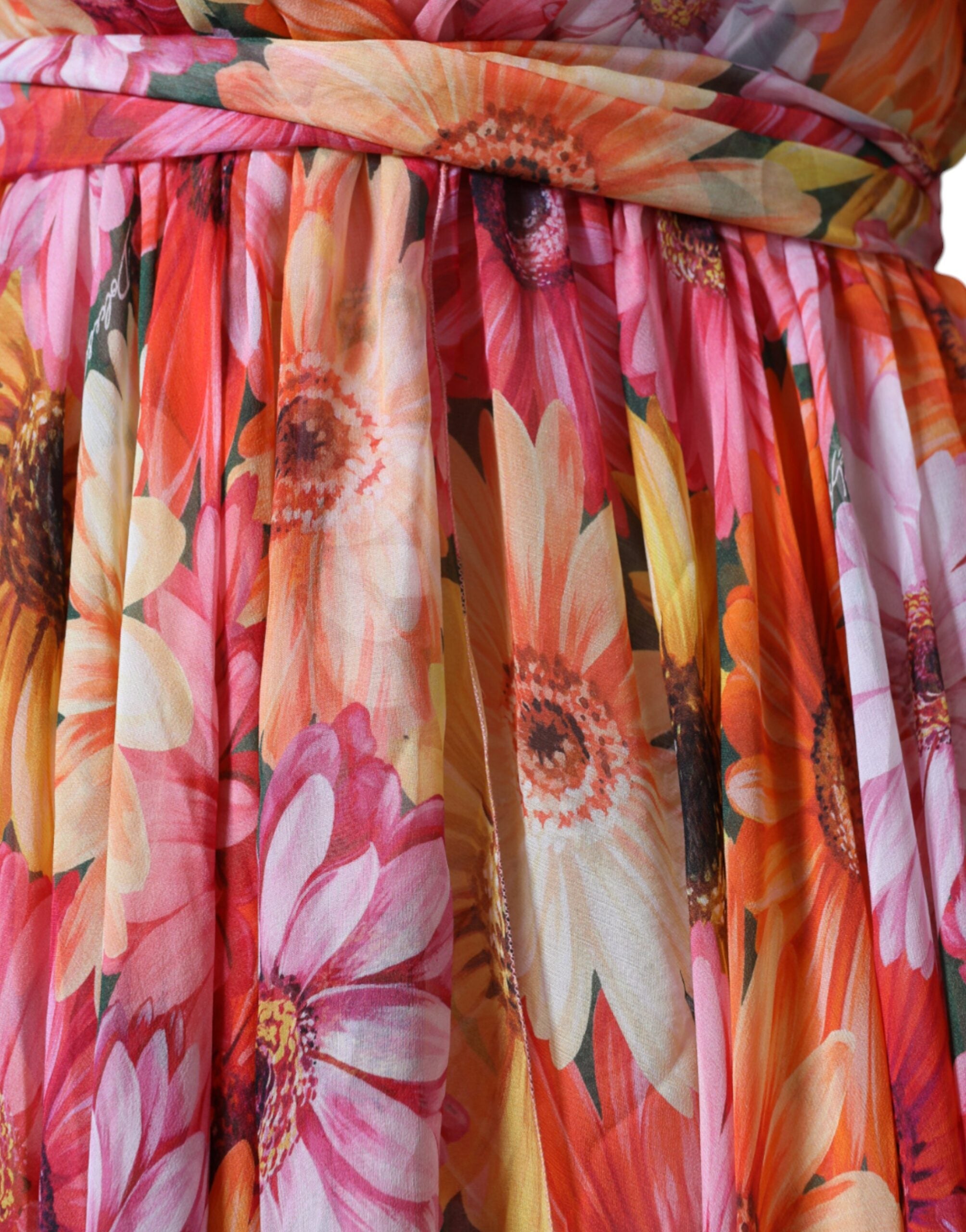 Dolce & Gabbana multicolor floral sleeveless V-neck midi dress hanging on a mannequin. Bright, vibrant floral pattern with a V-neck design.