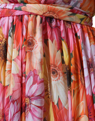 Dolce & Gabbana multicolor floral sleeveless V-neck midi dress hanging on a mannequin. Bright, vibrant floral pattern with a V-neck design.