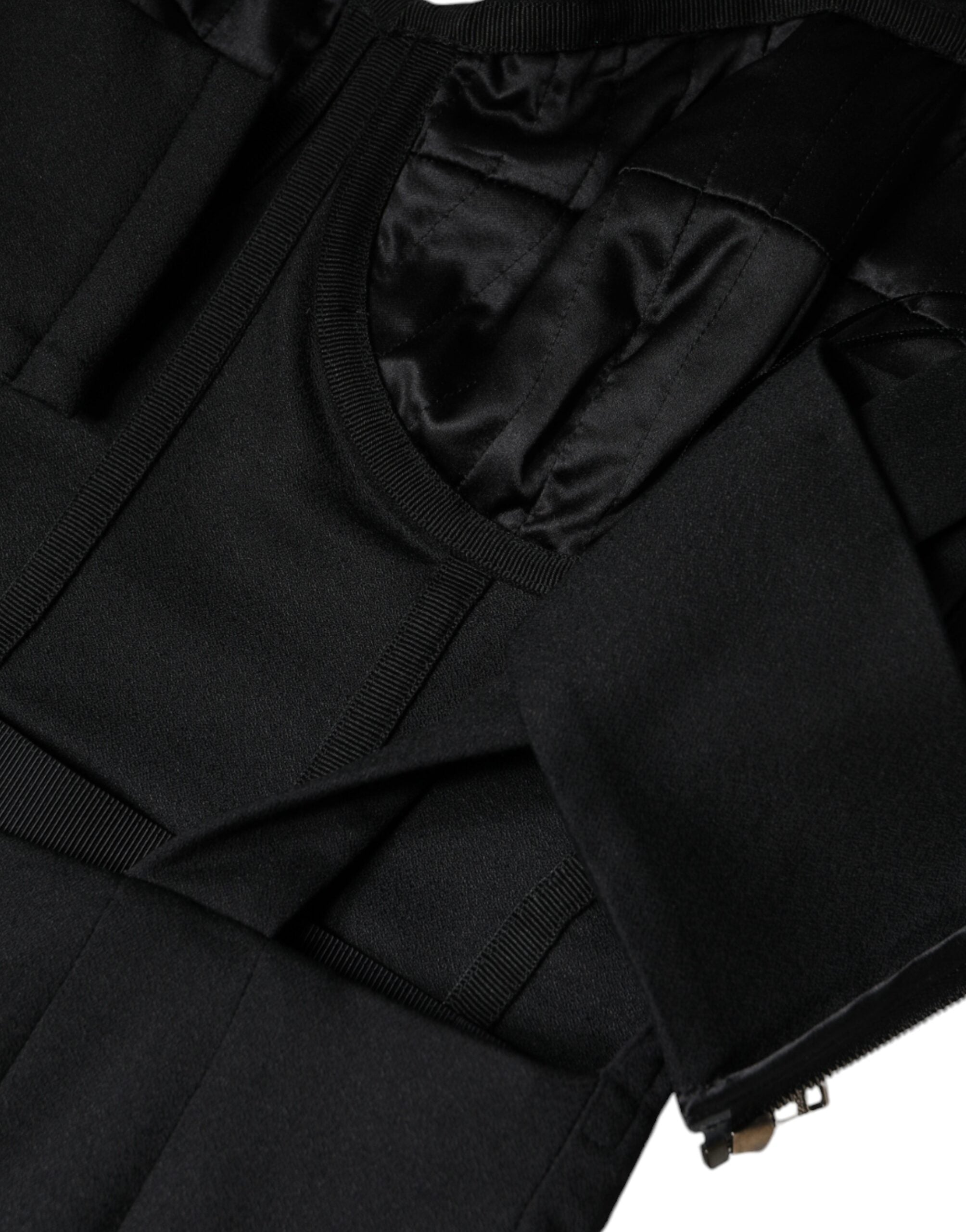 Black cut-out sleeveless bodycon mini dress by Dolce & Gabbana, shown on a model with a fitted silhouette and bold design details.