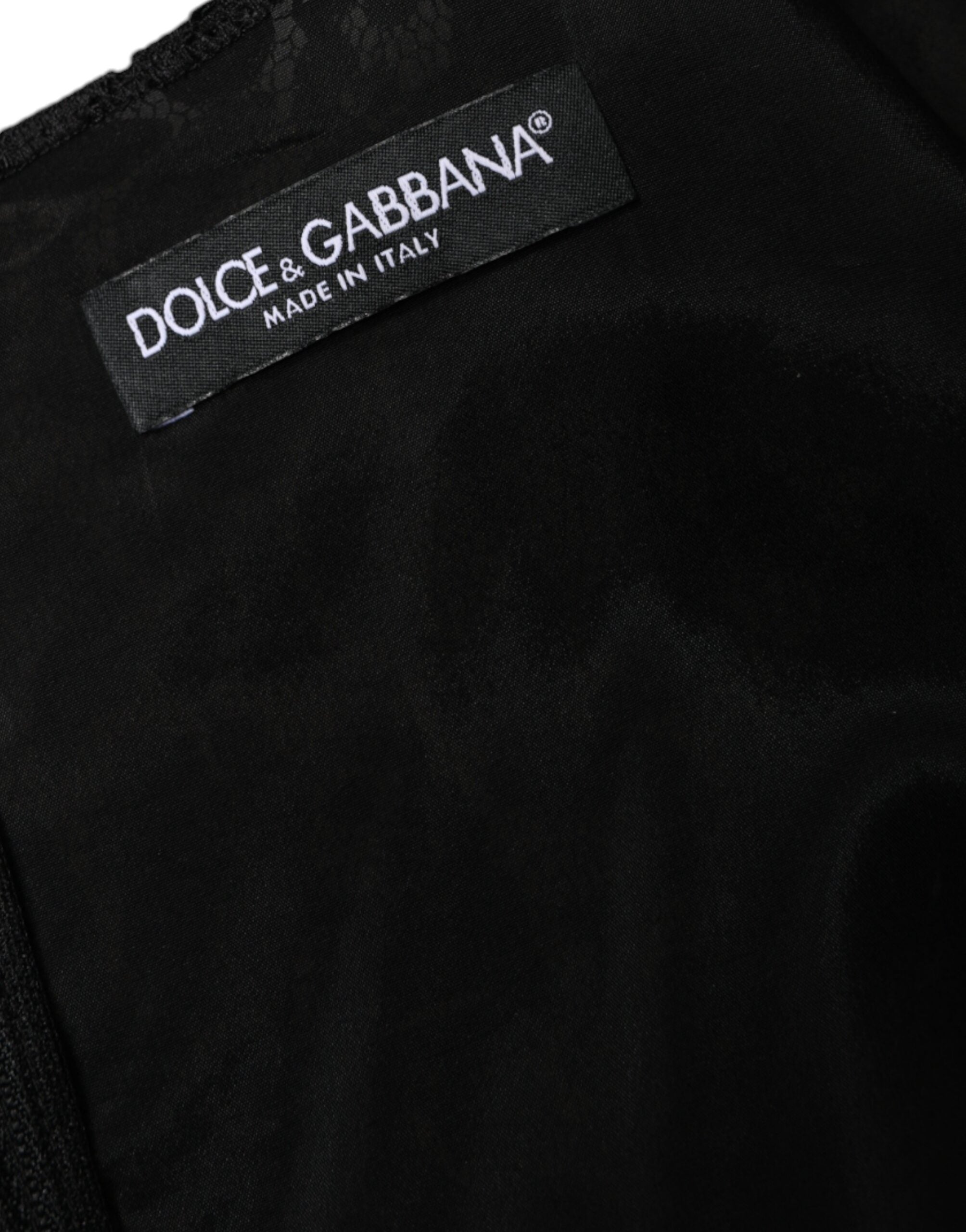 Black floral lace sheath sleeveless mini dress by Dolce & Gabbana displayed on a hanger with intricate lace details.