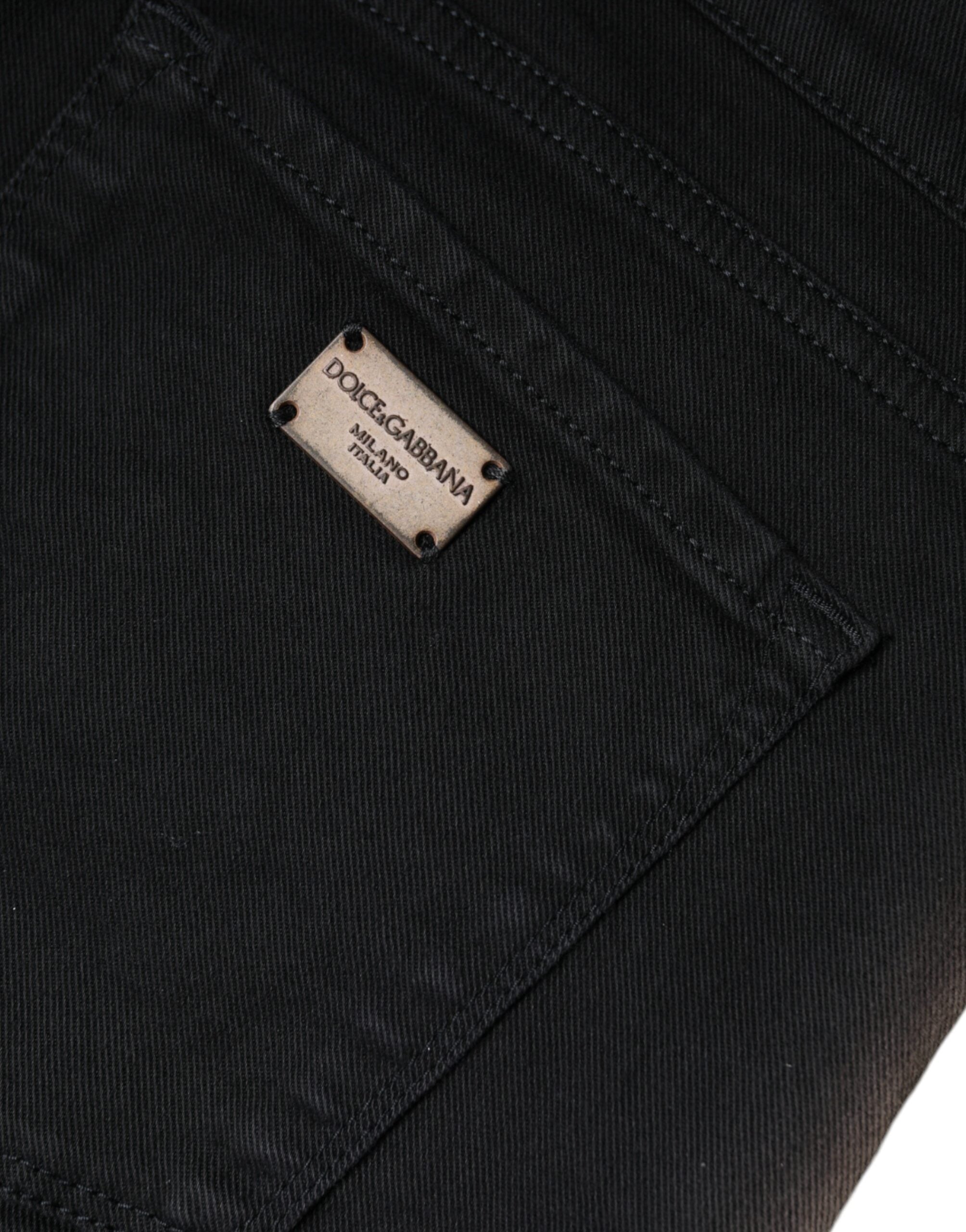 Black cotton stretch skinny denim jeans by Dolce & Gabbana, close-up of fitted style and classic five-pocket design.