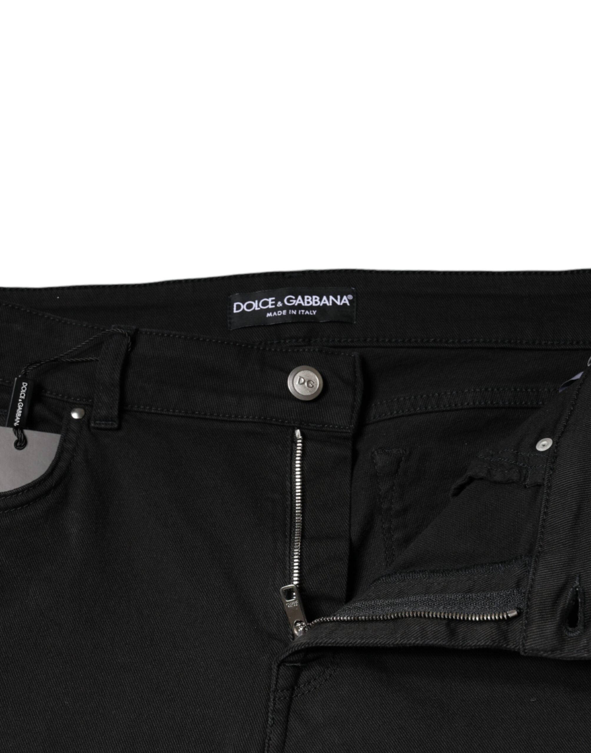 Black cotton stretch skinny denim jeans by Dolce & Gabbana, shown on a hanger with a close-up of fabric and fit details.
