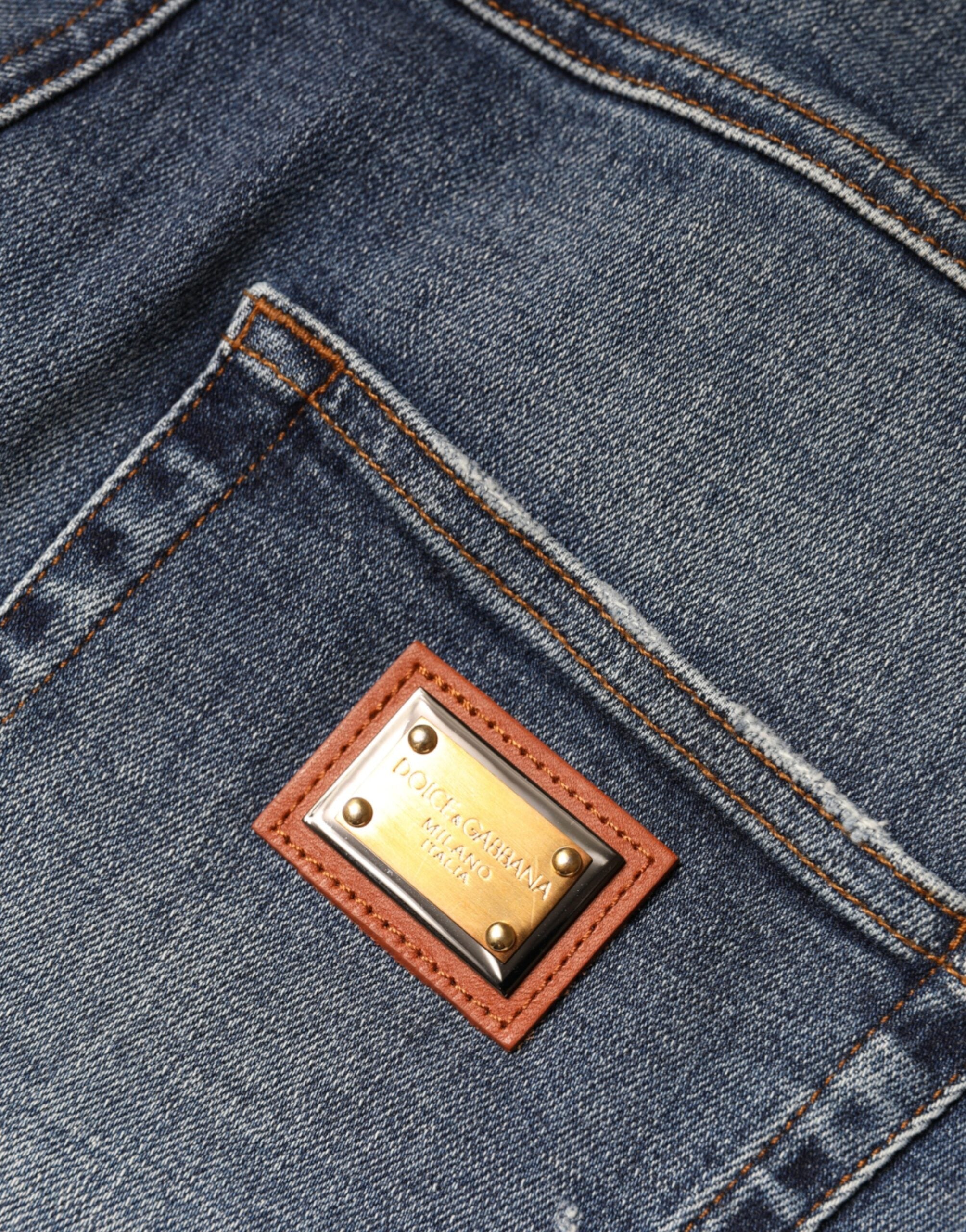 Dark blue cotton tattered skinny denim jeans by Dolce & Gabbana, showing distressed details and fitted silhouette.