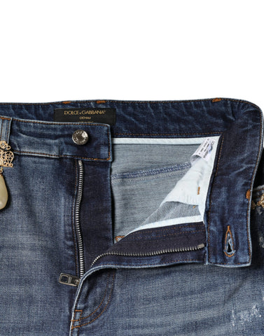 Dark blue cotton tattered skinny denim jeans by Dolce & Gabbana displayed on a model.