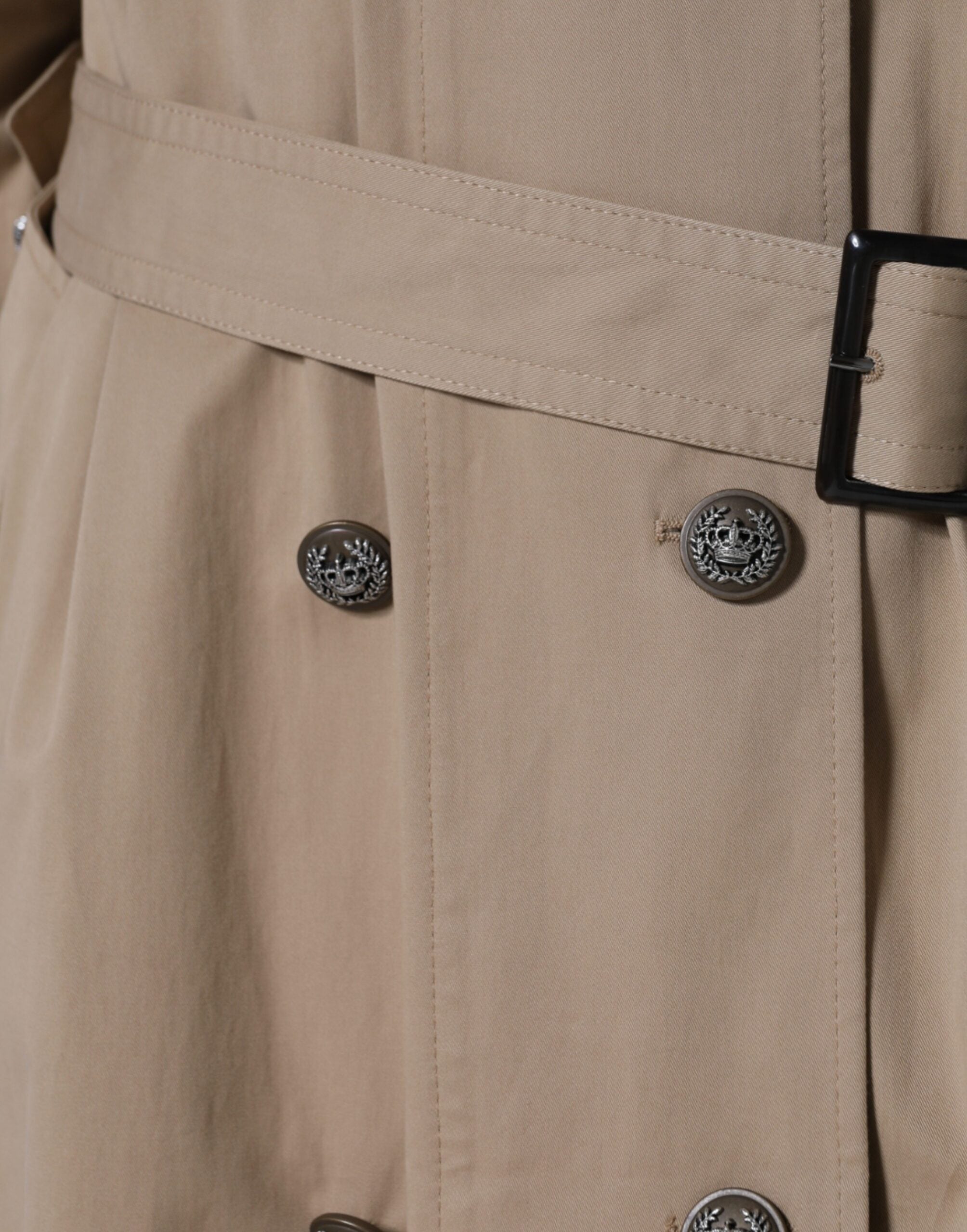 Dolce & Gabbana khaki double-breasted trench coat jacket displayed on a hanger, featuring classic design and button details.