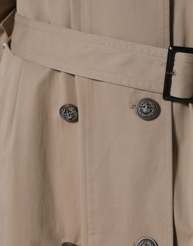 Dolce & Gabbana khaki double-breasted trench coat jacket displayed on a hanger, featuring classic design and button details.