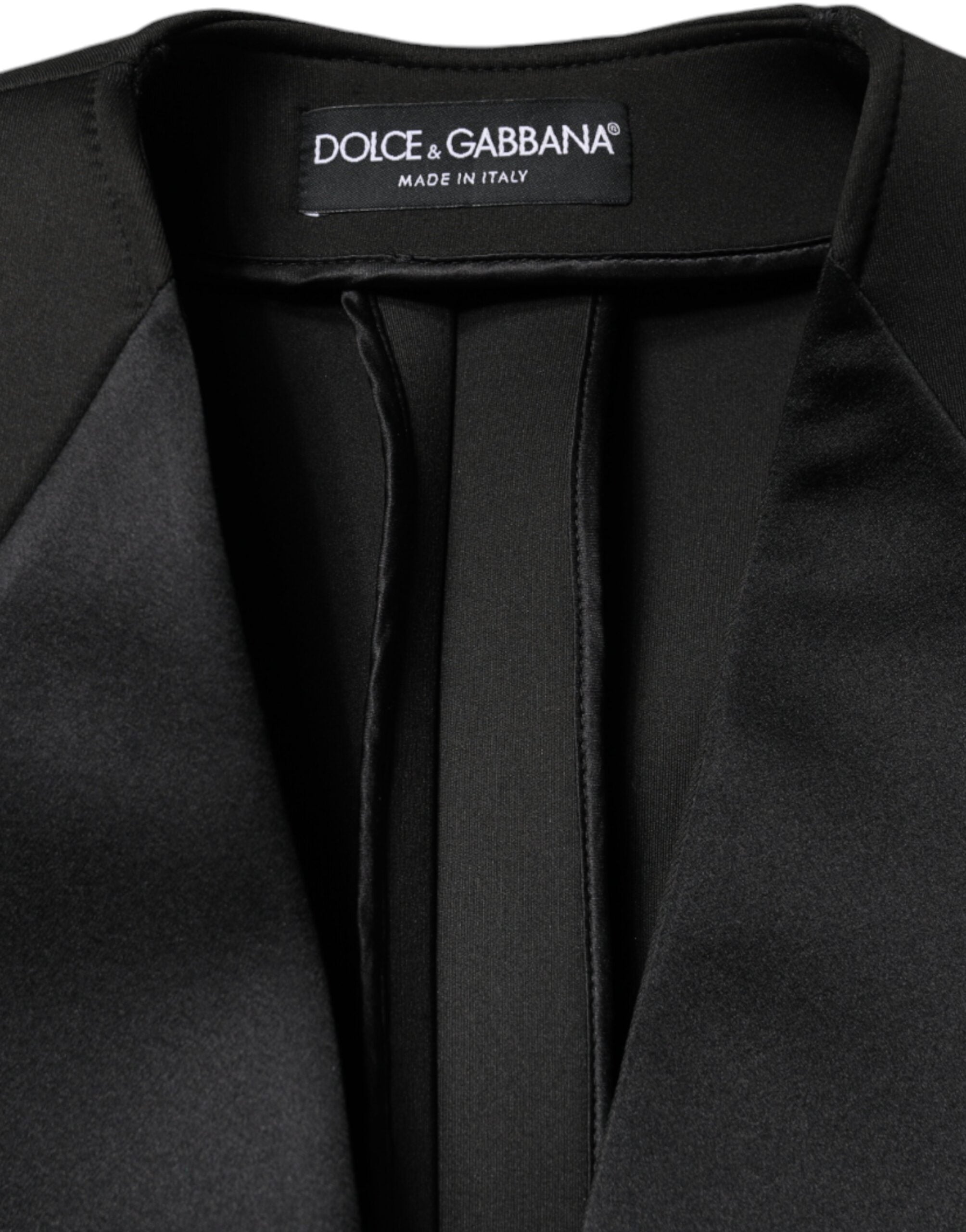 Black polyester double-breasted coat jacket by Dolce & Gabbana displayed on a hanger, showcasing classic tailored design and lapel details.