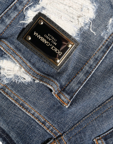 Blue cotton stretch tattered skinny jeans by Dolce & Gabbana, showing distressed details and slim fit cut.