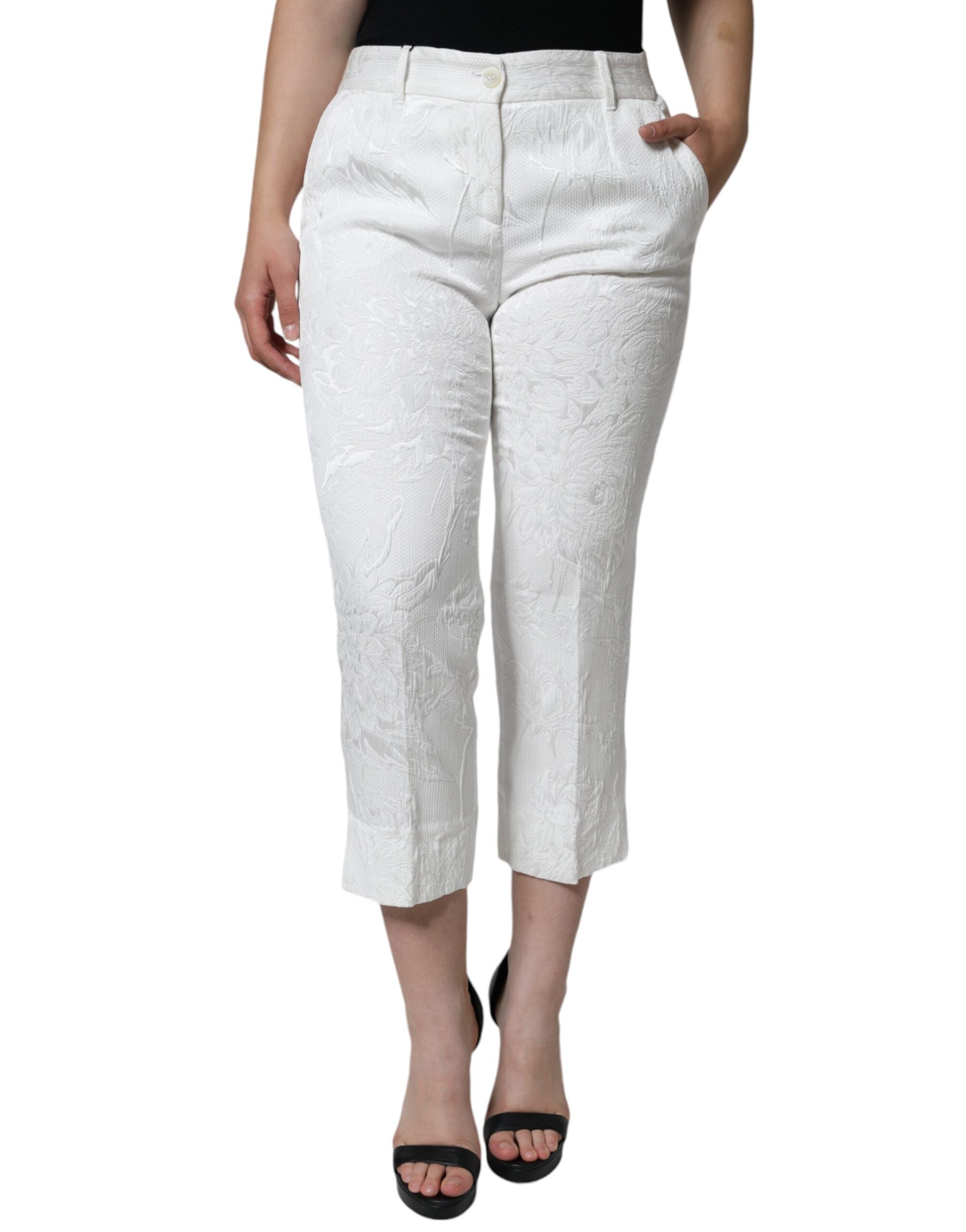 White floral brocade cotton cropped pants by Dolce & Gabbana, featuring intricate floral patterns and a tailored fit.