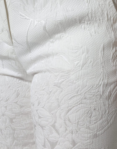 White floral brocade cotton cropped pants by Dolce & Gabbana with intricate floral pattern and tailored fit.