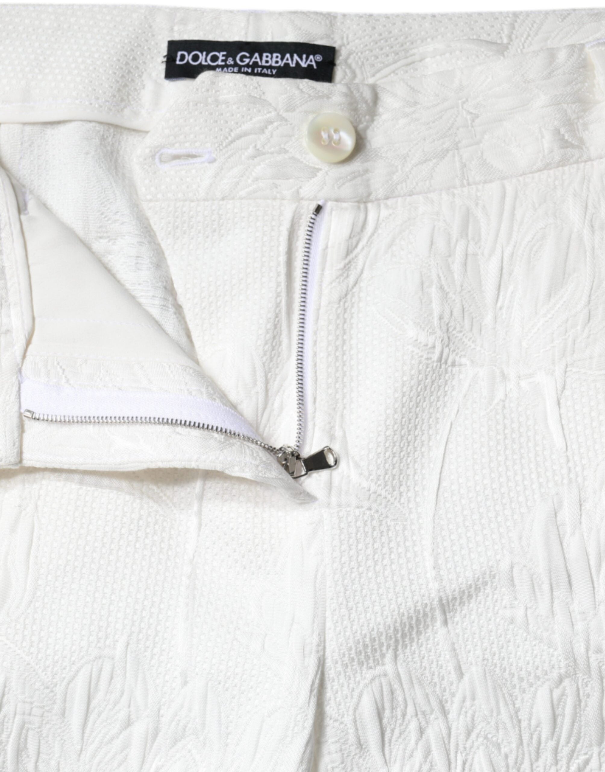White floral brocade cotton cropped pants by Dolce & Gabbana, featuring intricate floral pattern and tailored fit.