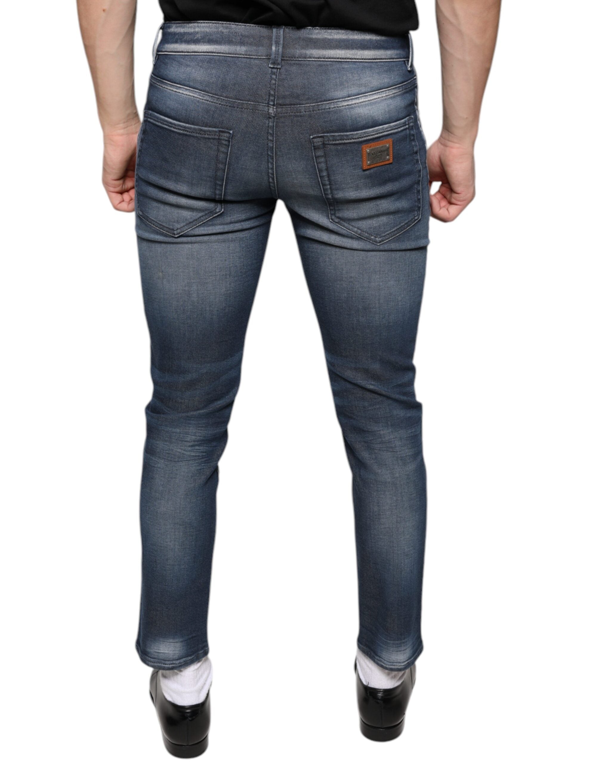 Dark blue washed cotton skinny denim jeans by Dolce & Gabbana displayed on a hanger with visible stitching and fading details.
