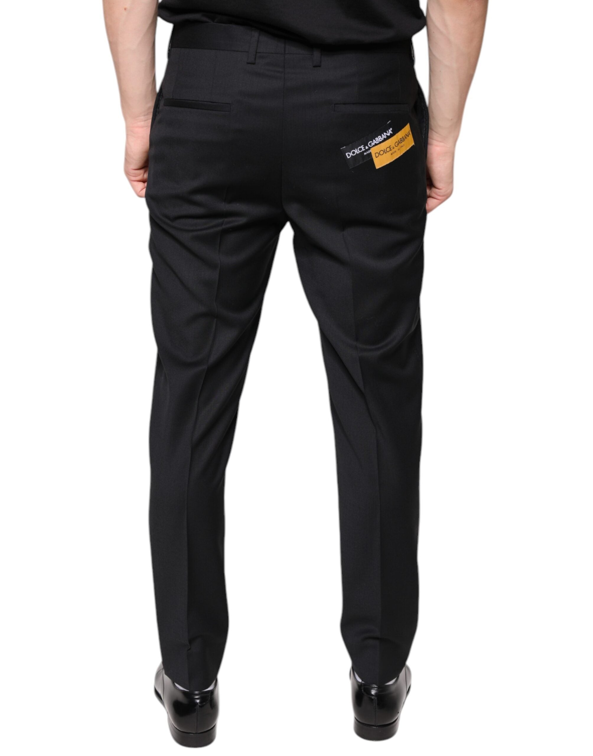 Black wool skinny men's dress pants by Dolce & Gabbana shown on a model, featuring a tailored fit and classic design.