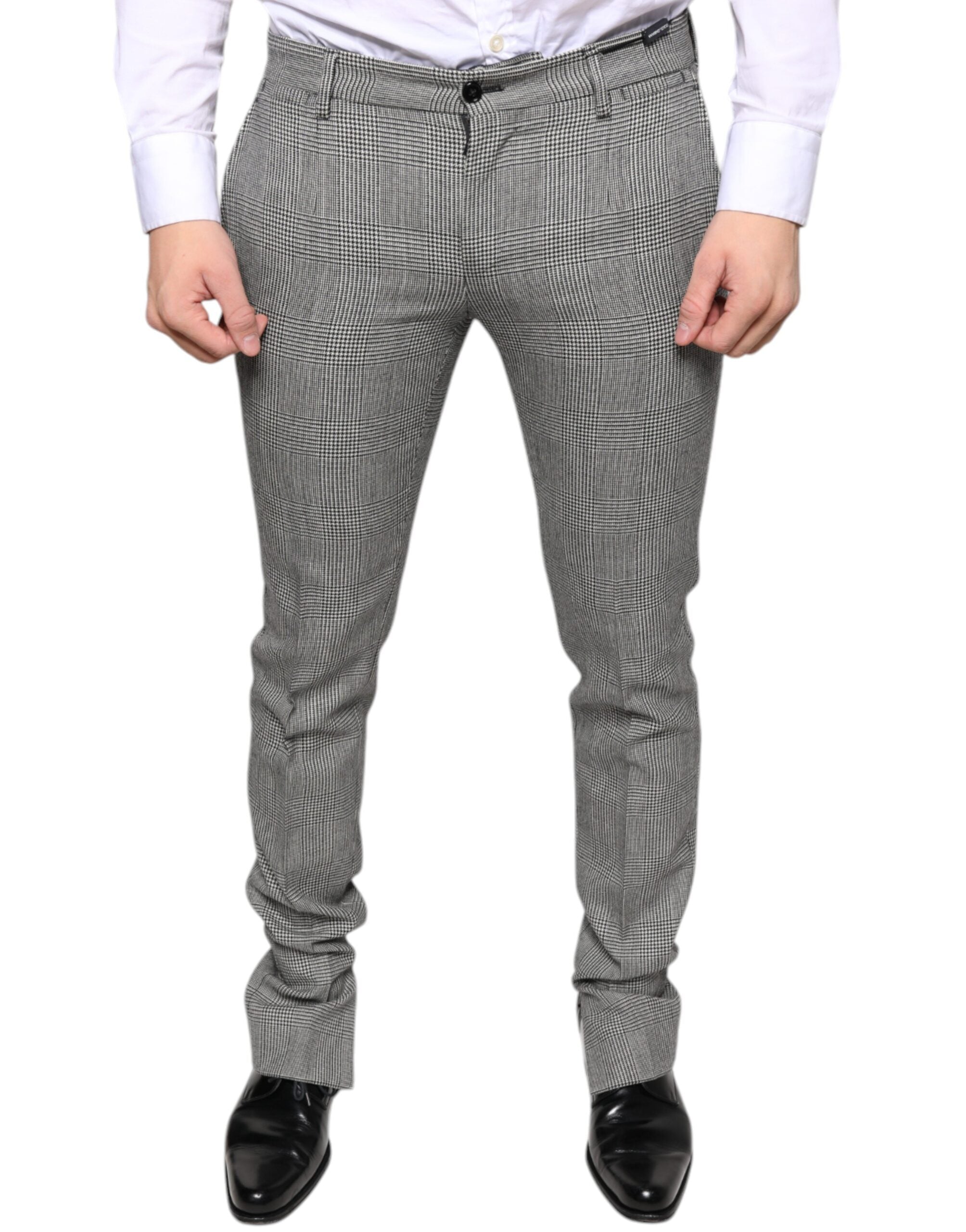 Gray check tartan wool skinny pants by Dolce & Gabbana, showing close-up of tailored fit and plaid pattern fabric.
