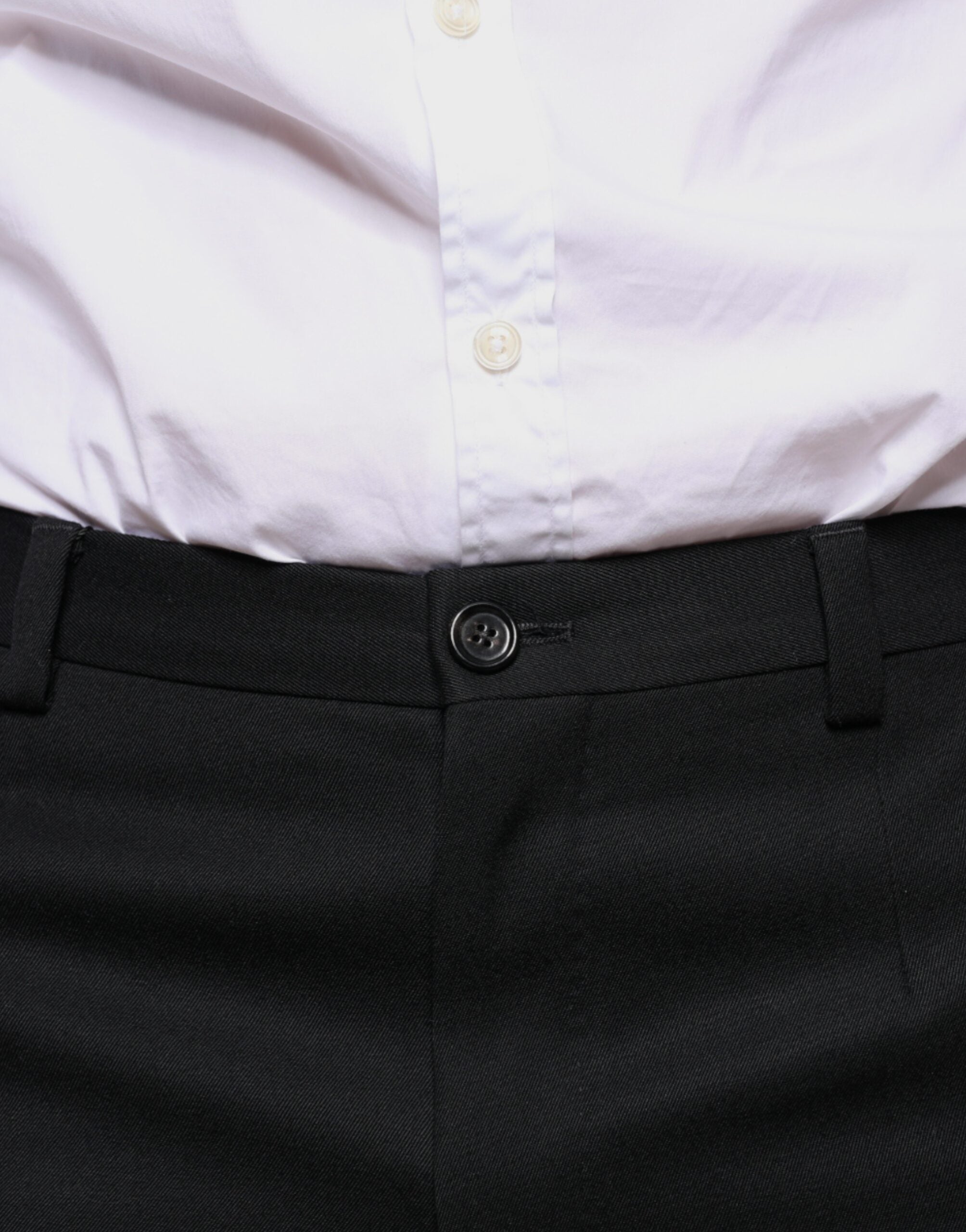 Black wool skinny men's dress pants by Dolce & Gabbana, tailored fit with sleek front and back pockets, close-up view.