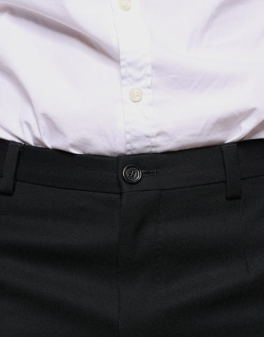 Black wool skinny men's dress pants by Dolce & Gabbana, tailored fit with sleek front and back pockets, close-up view.