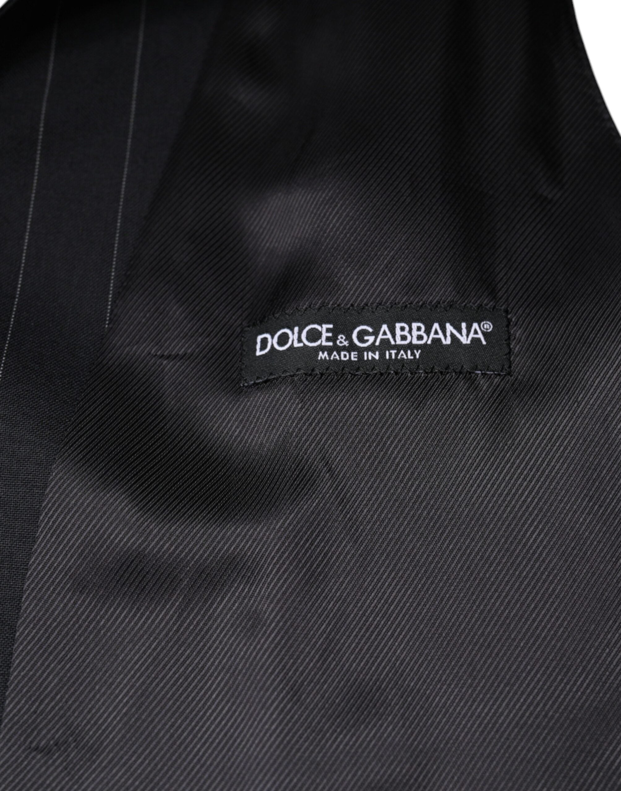 Black leather waistcoat dress with formal vest style by Dolce & Gabbana, shown on a mannequin.