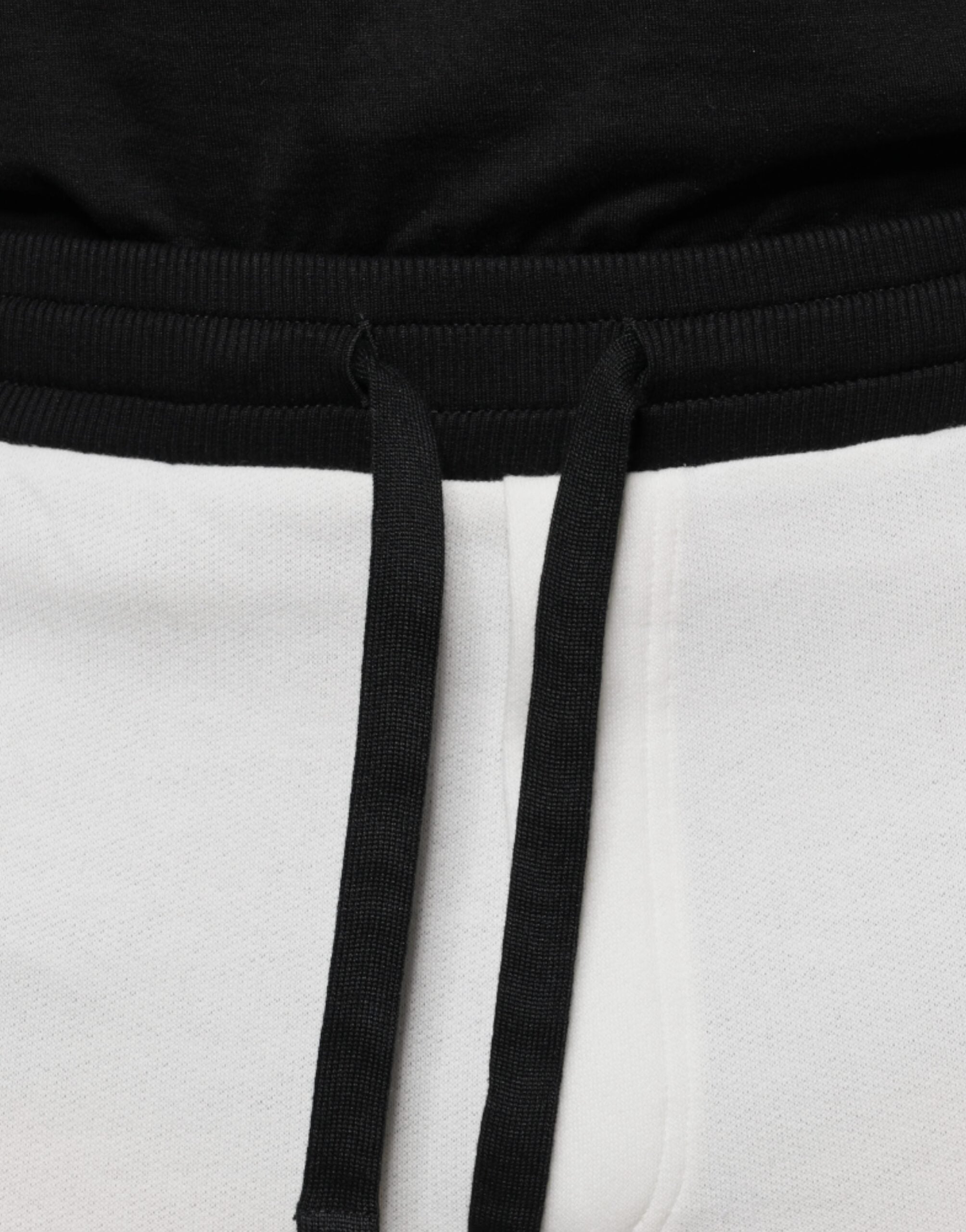 White cotton slim men's jogger sweatpants by Dolce & Gabbana, showing a relaxed fit with elastic waistband and tapered cuffs.