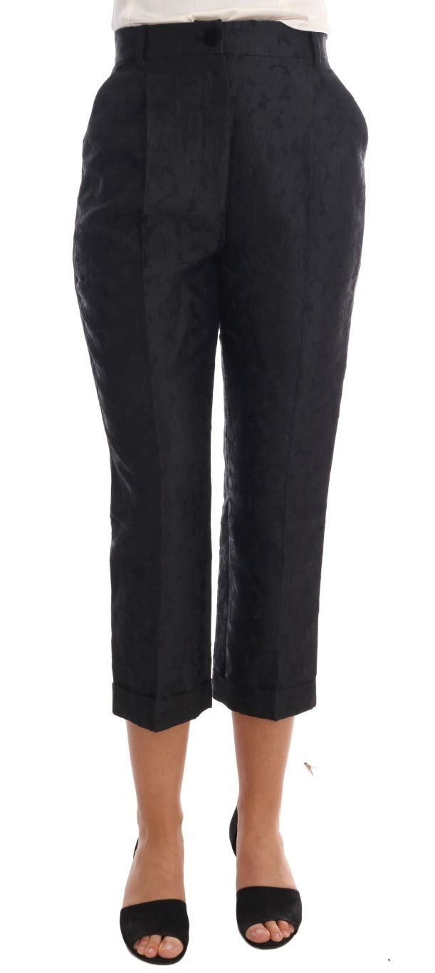 Black floral brocade Capri pants by Dolce & Gabbana, featuring intricate floral patterns and tailored fit.