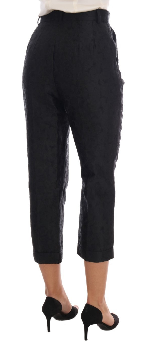 Black floral brocade Capri pants by Dolce & Gabbana, featuring intricate floral patterns and tailored fit.