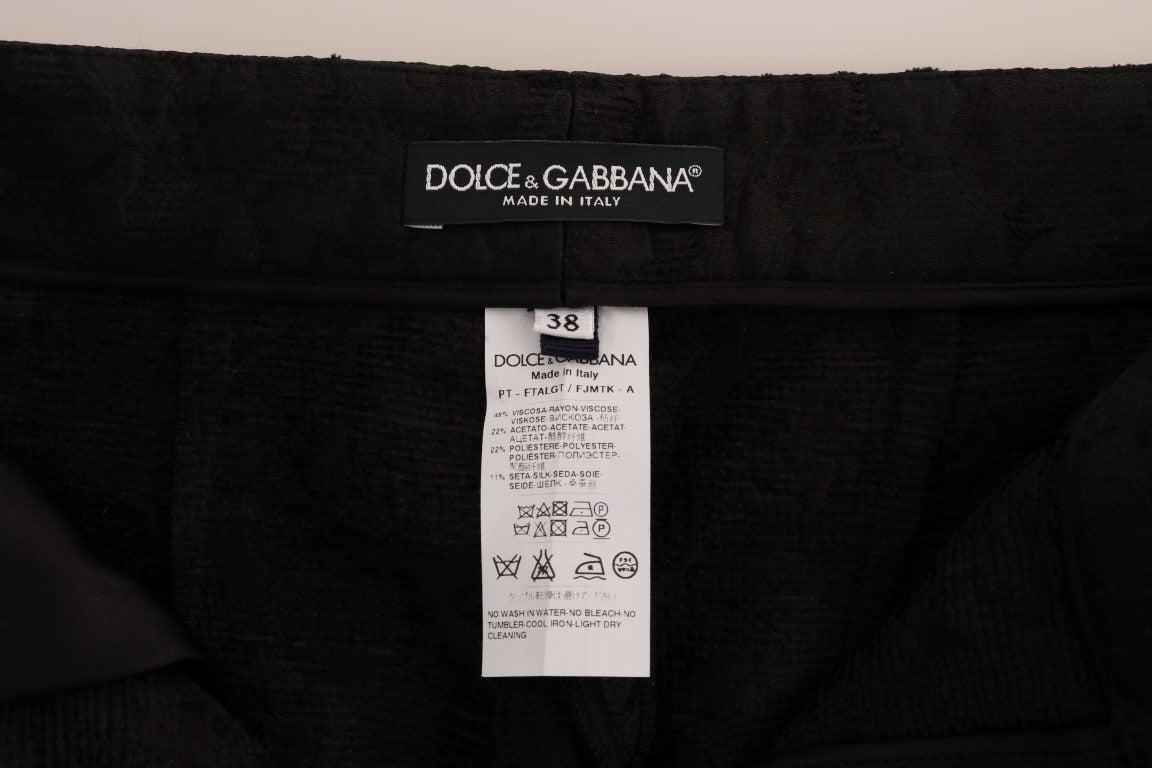 Black floral brocade Capri pants by Dolce & Gabbana with intricate floral patterns and tailored fit.