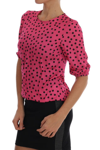 Pink polka dotted silk blouse by Dolce & Gabbana displayed on a model, highlighting the elegant design and vibrant pattern.