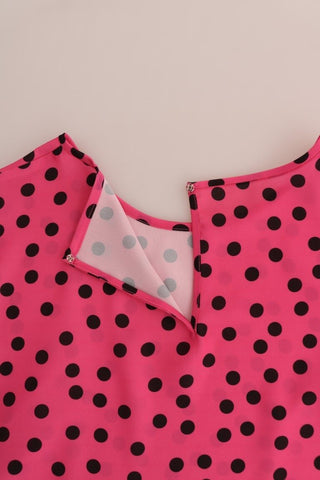 Pink polka dotted silk blouse by Dolce & Gabbana, shown with long sleeves and a classic collar, displayed on a hanger.