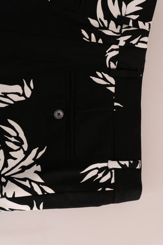 Black tree-patterned cotton stretch pants by Dolce & Gabbana, shown with a focus on the tailored fit and detailed pattern.
