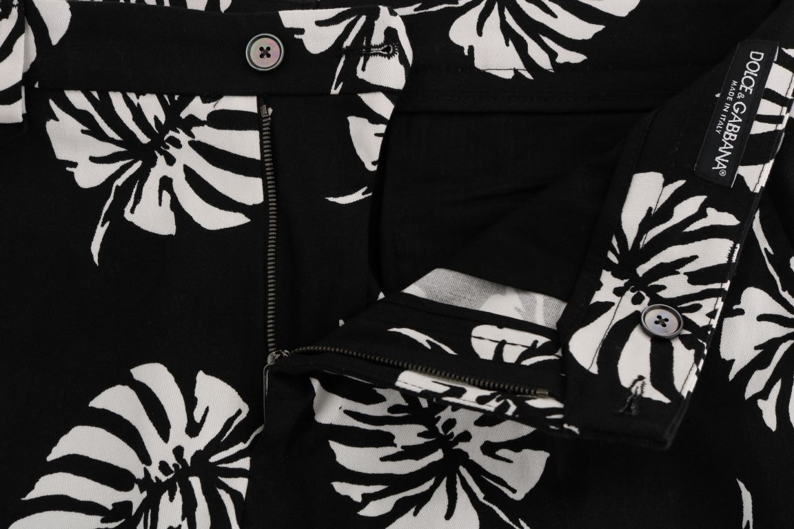 White and black leaf print cotton stretch slim pants by Dolce & Gabbana, showcasing a fitted design with a stylish leaf pattern.