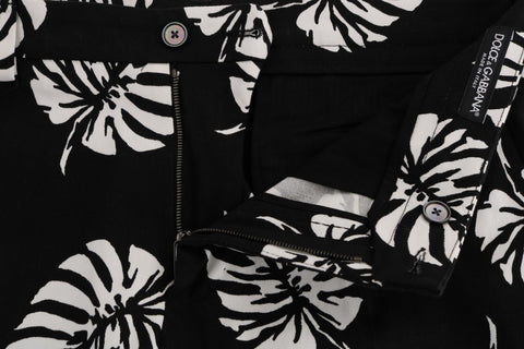 White and black leaf print cotton stretch slim pants by Dolce & Gabbana, showcasing a fitted design with a stylish leaf pattern.