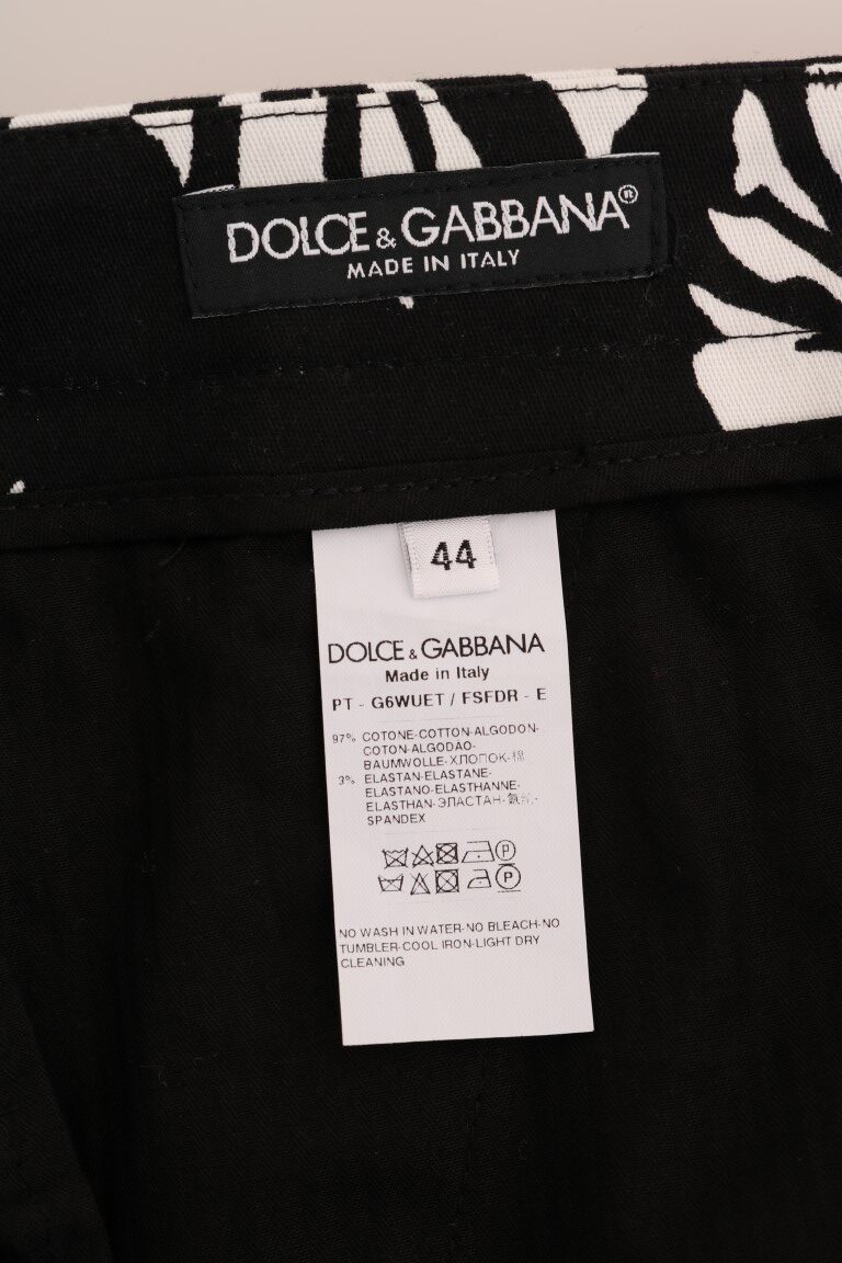White and black leaf print cotton stretch slim pants by Dolce & Gabbana, featuring a fitted design and stylish pattern.
