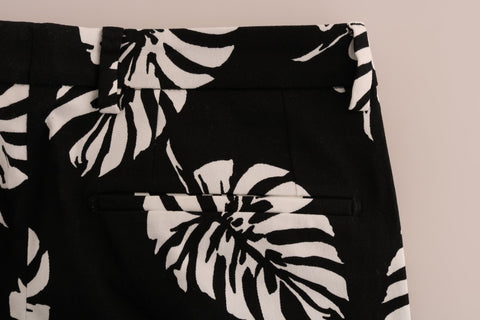 White and black leaf print cotton stretch slim pants by Dolce & Gabbana, featuring a tailored fit and stylish leaf pattern.
