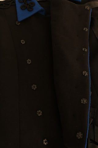 Black wool trench jacket by Dolce & Gabbana, shown on a hanger with a classic double-breasted design and belt details.