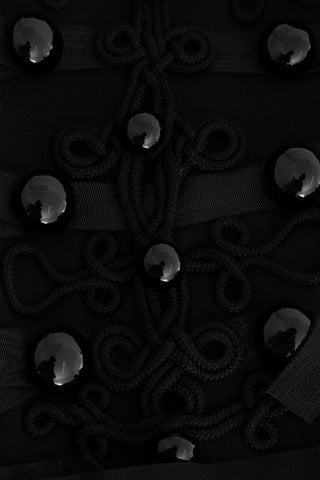 Black wool trench jacket by Dolce & Gabbana, shown in a rotated view with classic double-breasted design and belt details.