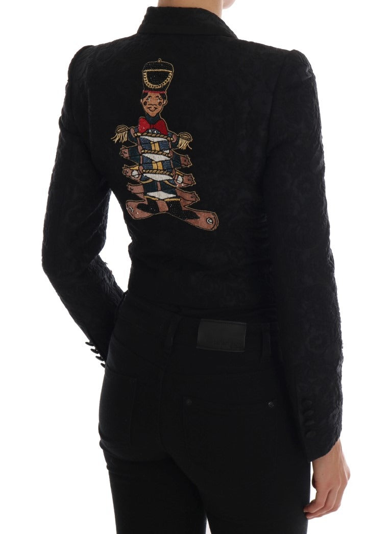 Black brocade blazer jacket by Dolce & Gabbana, featuring intricate woven fabric and tailored fit, displayed on a hanger.