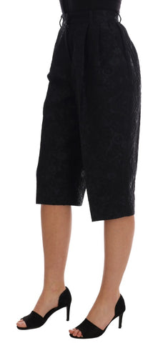 Black brocade high waist capri shorts by Dolce & Gabbana with intricate floral pattern and tailored fit.